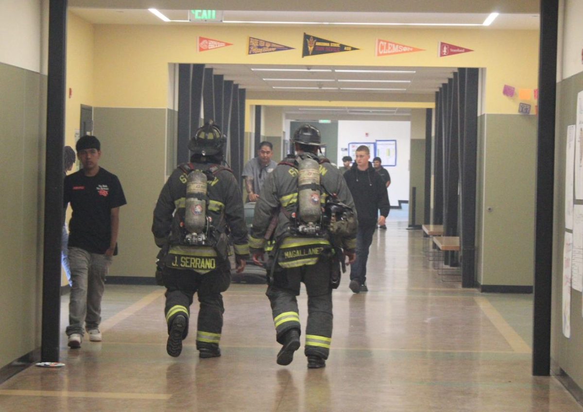 Stockton firefighters walk down the C-Building hallway after students were allowed back into classrooms following the fireworks explosion on May 29. 