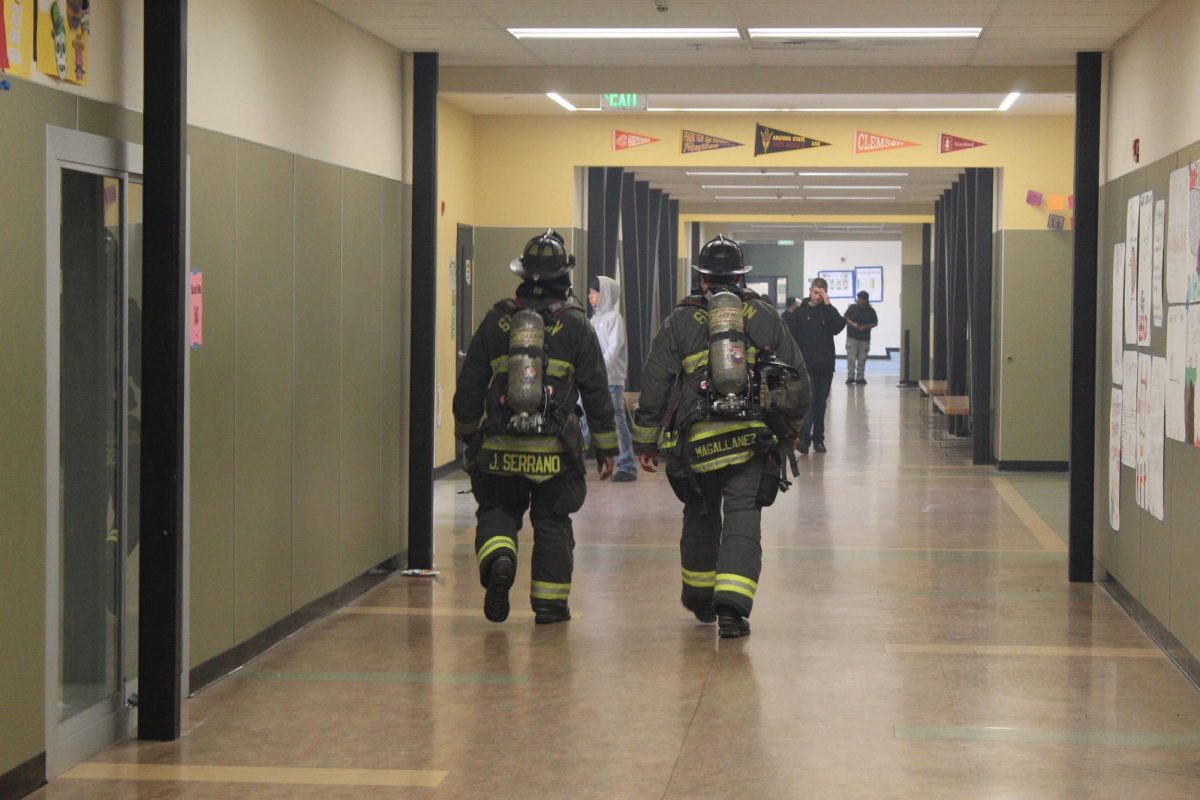 Stockton firefighters walk down the C-Building hallway after students were allowed back into classrooms following the fireworks explosion on May 29. 