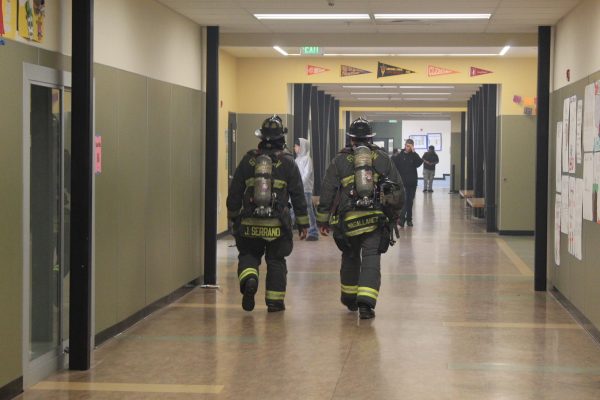 Stockton firefighters walk down the C-Building hallway after students were allowed back into classrooms following the fireworks explosion on May 29. 