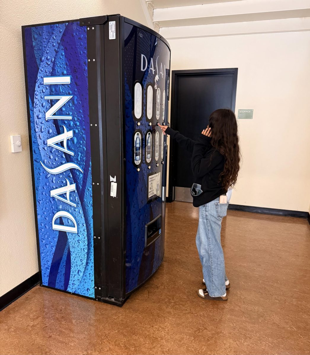 An FHS student gazes in sorrow at the long-deceased corpse of our once beloved vending machine. 